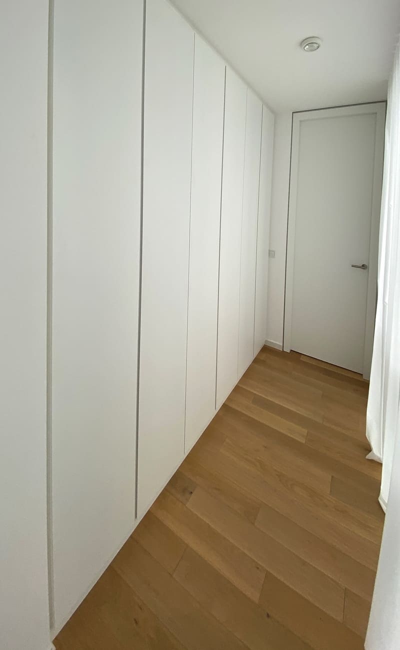 Ganzflächiger Einbauschrank im Flur mit sehr viel Stauraum Einbauschrank nach Maß ganzflächig im Flur in Weiß