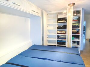 Schrankbett geöffnet mit offenem Kleiderschrank